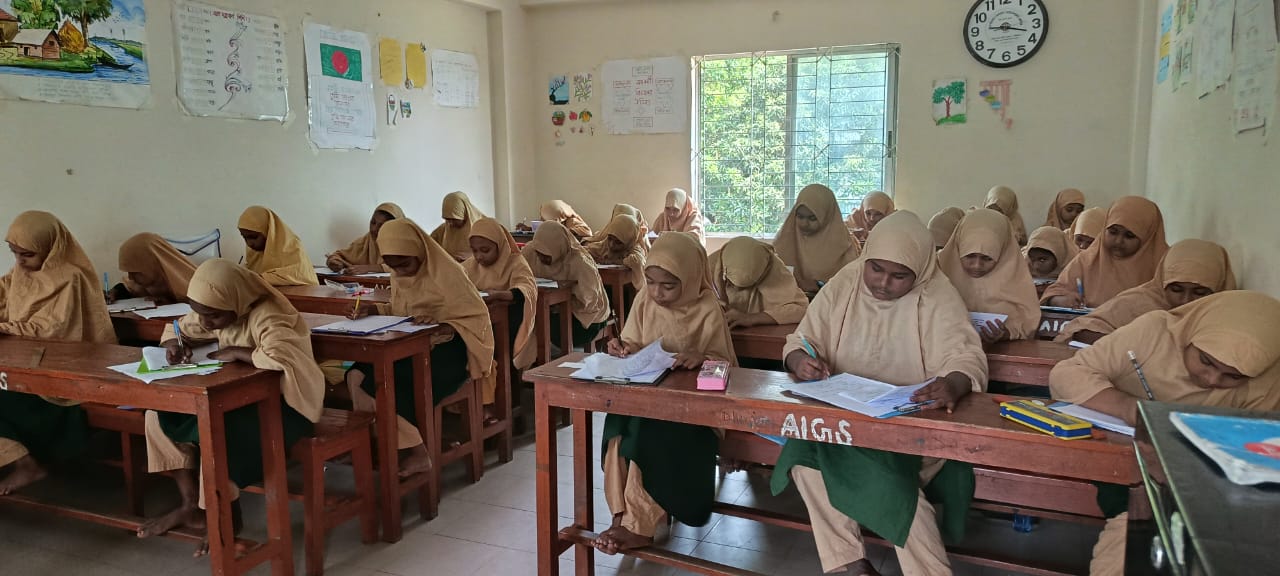 Girls holding their schoolbooks at Al-Ihsan