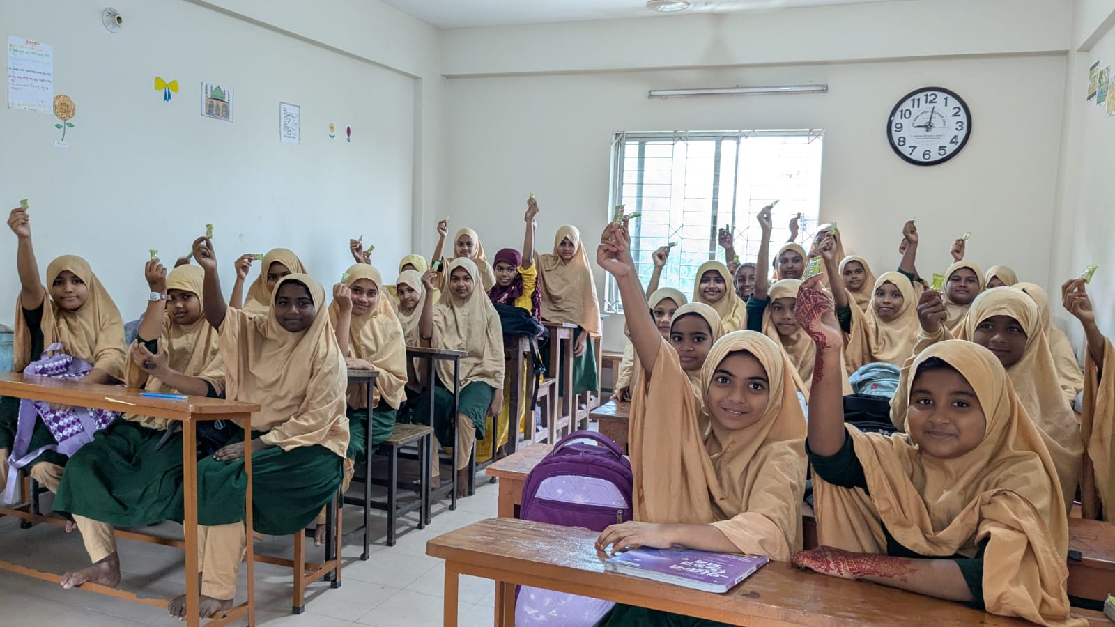 Girls at Al-Ihsan Girls' School holding their books